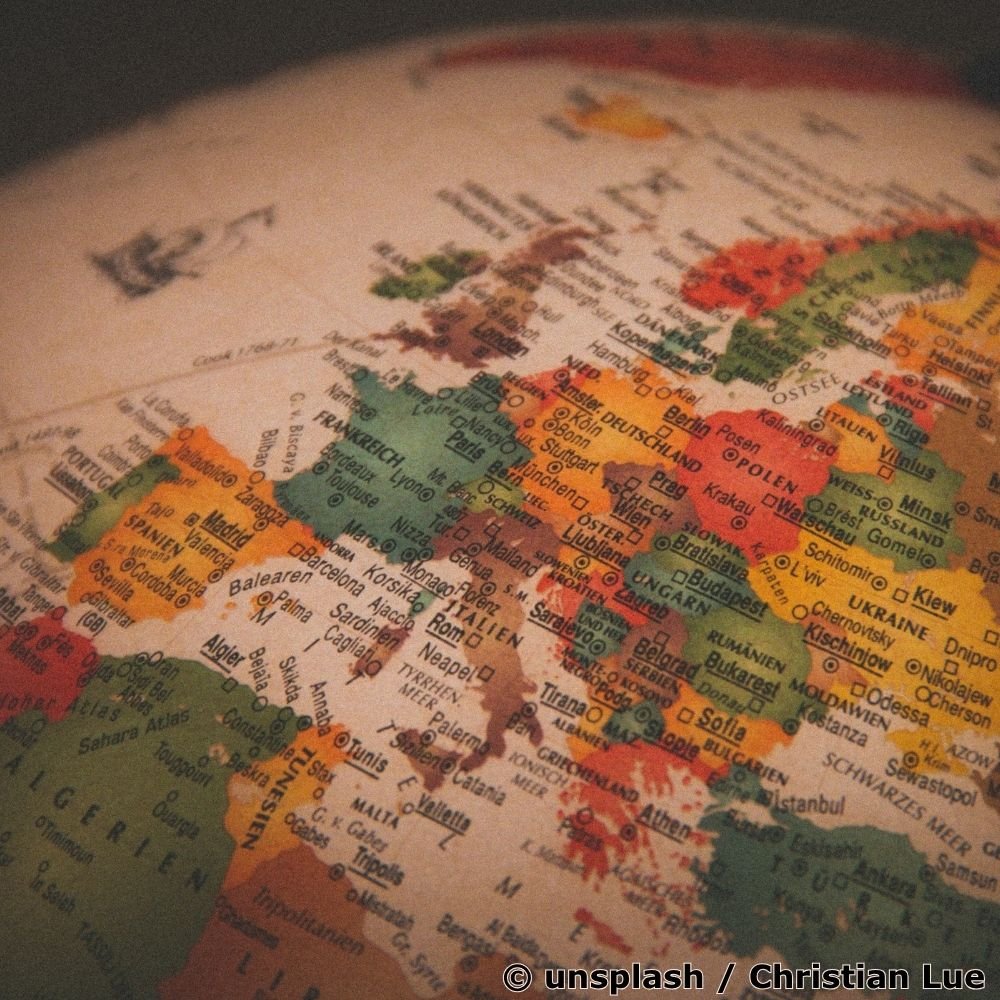 Nahaufnahme eines beleuchteten Globus mit Fokus auf Europa, auf dem Länder wie Frankreich, Deutschland und weitere europäische Staaten in verschiedenen Farben dargestellt sind.
